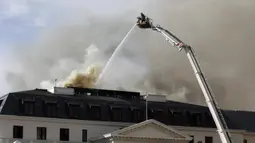 Asap mengepul dari Gedung Parlemen di Cape Town, Afrika Selatan, 3 Januari 2022. ​Setelah sempat berhasil dipadamkan, api kembali mengamuk dan membakar Gedung Parlemen Afrika Selatan. (AP Photo/Nardus Engelbrecht)