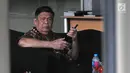 Mantan Bupati Buton Laode Muhammad Sjafei Kahar bermain ponsel saat menunggu untuk menjalani pemeriksaan di lobi gedung KPK, Jakarta, Rabu (17/7).  Sjafei Kahar diperiksa terkait suap proyek di wilayah Kabupaten Buton Selatan. (Merdeka.com/Dwi Narwoko)