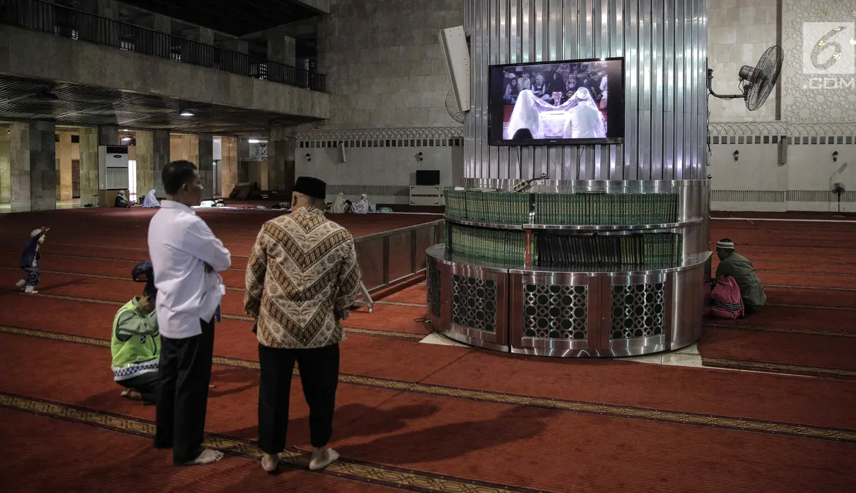 Sejumlah jemaah berdiri di depan layar yang menayangkan prosesi pernikahan Vicky Prasetyo dan Angel Lelga di Mesjid Istiqlal, Jakarta, Jumat (9/2). (Liputan6.com/Faizal Fanani)