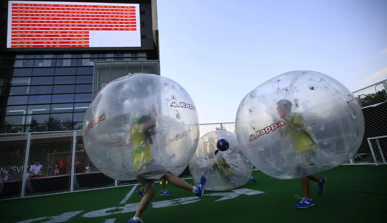 Para pemain mengolah si kulit bundar dari dalam sebuah gelembung berbentuk bola di Beijing, Kamis (10/7/14). (REUTERS/Kim Kyung-Hoon)