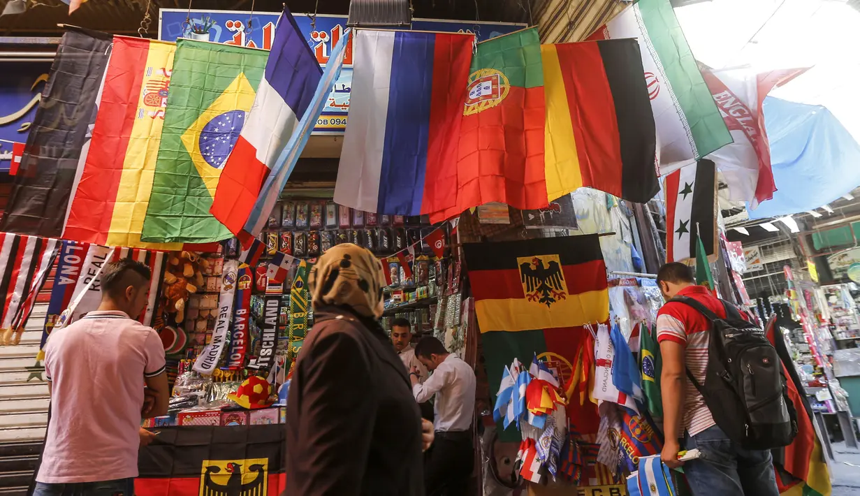 Sejumlah pembeli mencari pernak-pernik negara yang berpartisipasi pada Piala Dunia FIFA 2018 di jalan pasar di kota tua Damasku, Suriah (6/6). Piala Dunia akan digelar pada 14 Juni 2018 di Rusia. (AFP Photo/Louai Beshara)