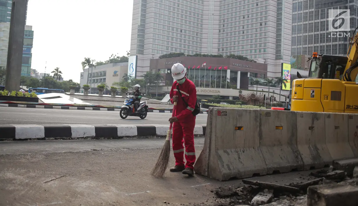 Pekerja dibantu alat berat merevitalisasi trotoar di kawasan Bundaran HI, Jakarta Pusat, Senin (15/7/2019). Penantaan ini dilakukan untuk mempercantik trotoar dan memberikan rasa nyaman bagi pejalan kaki. (Liputan6.com/Faizal Fanani)