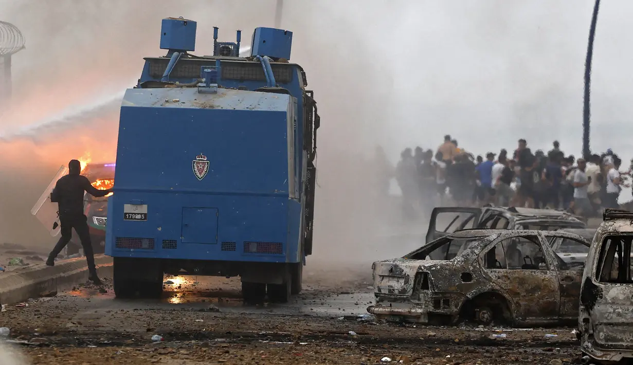 Kendaraan water canon pasukan keamanan Maroko menembakkan air  ke arah massa yang berkumpul di lokasi bentrokan dekat Fnideq, di perbatasan Maroko-Spanyol, Jumat, 31 Juli 2026. (AFP/  Abdel Majid Bziouat)