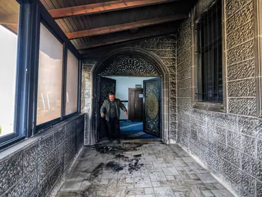 Seorang pria memeriksa pintu masuk Masjid Abu Bakr al-Siddiq di desa Tell, sebelah barat Nablus, Tepi Barat yang diduduki, pada 23 Februari 2026. (JAAFAR ASHTIYEH/AFP)