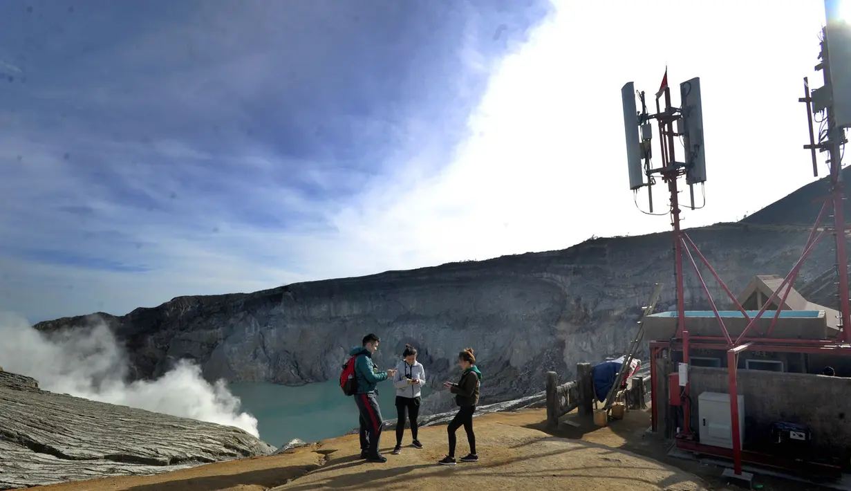 Wisatawan asal Malaysia bermain gawai dekat menara BTS di Puncak Kawah ijen, Banyuwangi, Selasa (3/7). Sejumlah operator telekomunikasi terus memasang menara BTS untuk mempermudah penggunanya di sejumlah tempat pariwisata. (Merdeka.com/Arie Basuki)