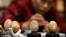Zhang Xiaohe membuat kerajinan ukiran telur di sebuah lokakarya warisan budaya takbenda di Shijiangzhuang, China pada 17 April 2020. Ukiran telur sering disebut "seni yang paling rapuh", karena membutuhkan ketelitian dan perhatian tinggi sebelum, selama dan setelah pembuatannya. (Xinhua/Chen Qibao)