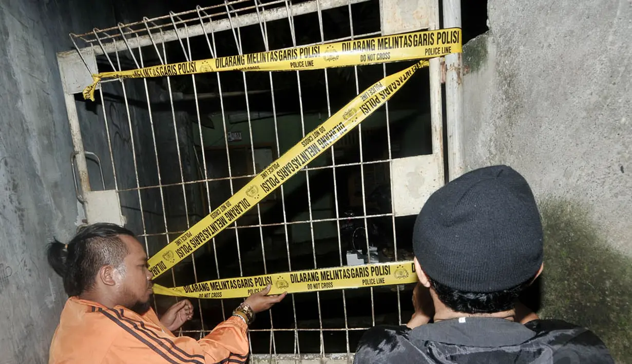 Rumah terduga teroris, Akbar alias Muri alias Donal (28) tampak gelap gulita dan terpasang garis polisi di pagar depan rumah terduga pelaku, Jakarta, Selasa (24/6/14). (Liputan6.com/Johan Tallo)