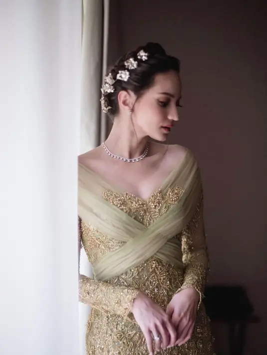 Tatanan braided updo yang dihiasi aksesori bunga keemasan oleh hair stylist @kim_mefta mempermanis tampilan Enzy. [Foto: IG/enzystoria.].