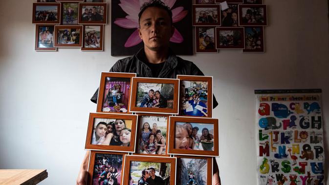 Jose Collantes memegang foto keluarga yang dicetaknya setelah sang istri meninggal karena COVID-19, di dalam rumahnya di mana dia merawat putri mereka yang berusia lima tahun, Kehity, dan mereka tinggal bersama saudara perempuannya di Santiago, Chili, Minggu, 6 September 2020. (AP/Esteban Felix)