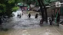 Warga berusaha melintasi banjir yang merendam perumahan Ciledug Indah, Tangerang, Banten, Kamis (2/1/2020). Memasuki hari kedua, kondisi perumahan tersebut masih tergenang banjir setinggi dada orang dewasa. (Liputan6.com/Angga Yuniar)