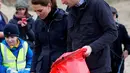 Pangeran William dan Kate Middleton, Duchess of Cambridge saat membantu anak-anak sekolah membersihkan sampah di pantai Newborough di Wales (8/5). Pangeran William dan Kate Middleton melakukan kunjungan ke pantai Newborough untuk membersihkan sampah yang berserakan. (Reuters/Phil Noble)