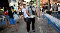 Seorang petugas kesehatan (kanan) menyemprotkan disinfektan di kawasan wisata di Sanur, Bali, Senin (16/3/2020). Penyemprotan dilakukan sebagai salah satu langkah untuk mengantisipasi potensi penyebaran virus Corona COVID-19 di kawasan pariwisata tersebut. (SONNY TUMBELAKA/AFP)