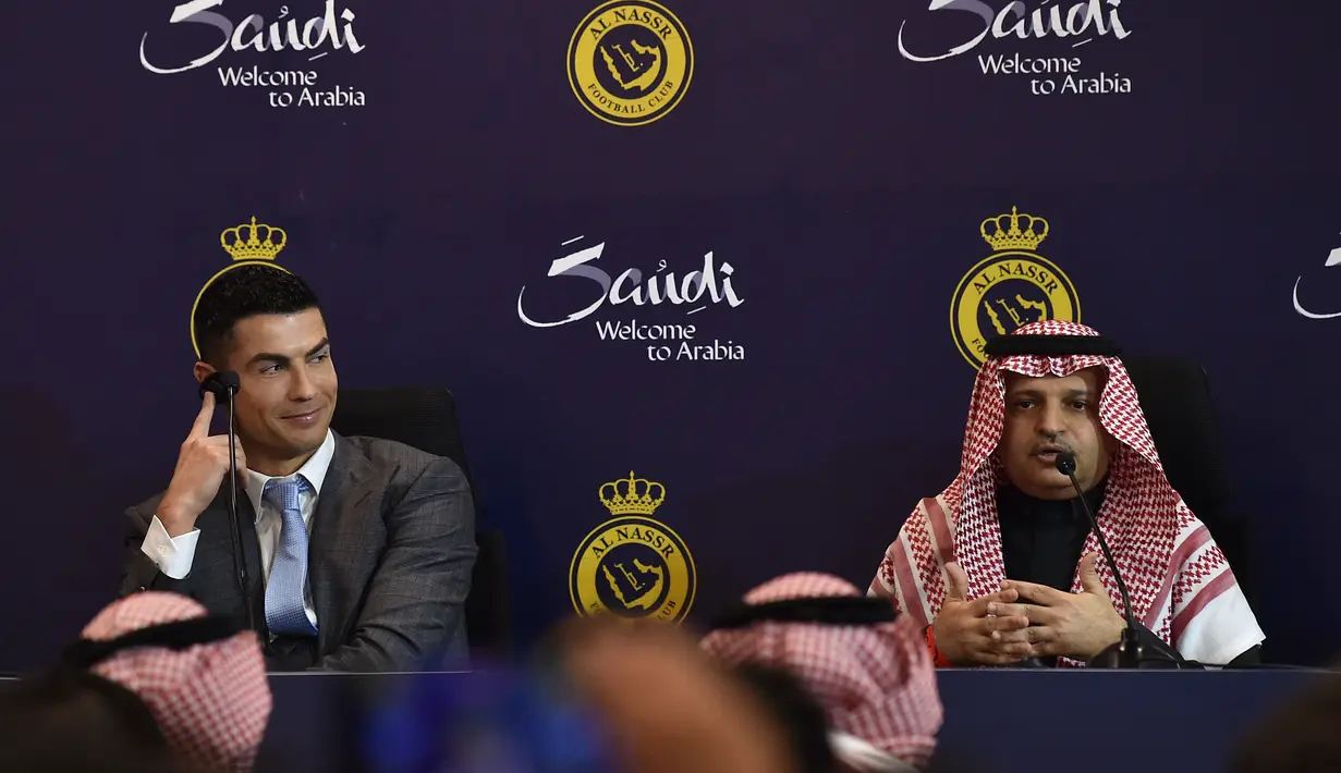 Penyerang Portugal, Cristiano Ronaldo bersama Presiden Al-Nassr Musalli Al-Muammar mendengarkan laporan selama konferensi pers di Stadion Mrsool Park di Riyadh, Arab Saudi, Selasa (3/1/2023). Ronaldo, yang telah memenangkan lima penghargaan Ballon d'Ors sebagai pemain sepak bola terbaik di dunia dan lima gelar Liga Champions, akan bermain di luar Eropa untuk pertama kalinya dalam karirnya. (Photo by AFP)
