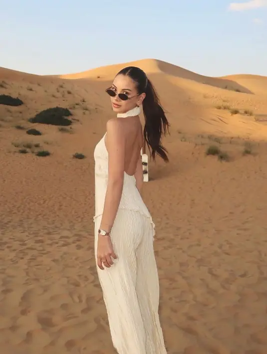 Sementara itu,  Alyssa saat di padang pasir mengenakan setelan warna putih. Dari atasan halter neck asimetris backless dan celana panjangnya. [@alyssadaguise]