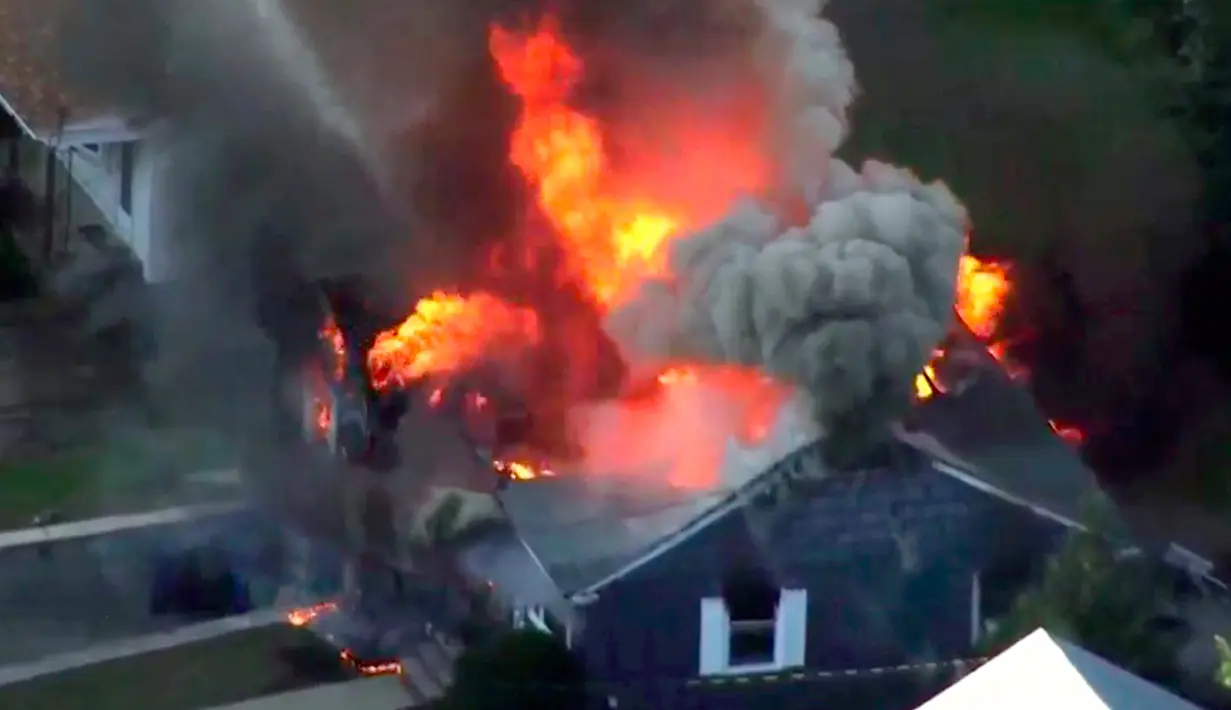 Gambar dari rekaman video memperlihatkan kobaran api membakar rumah di Lawrance, dekat Boston, Amerika Serikat (AS), Kamis (13/9). Rentetan ledakan dan kebakaran yang melanda tiga komunitas di utara Boston itu memaksa seluruh warga mengungsi (WCVB via AP)