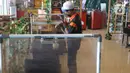 Petugas membersihkan pembatas plastik di salah satu restoran Mall Bekasi, Jawa Barat, Minggu (7/6/2020). Sejumlah tempat makan mulai menerapkan protokol kesehatan untuk pengunjung yang makan ditempat untuk mencegah penyebaran wabah COVID-19. (Liputan6.com/Herman Zakharia)