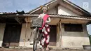 Seorang gadis menggunakan sepeda saat hendak menuju titik kumpul untuk mengikuti upacara adat Ngarot di Desa Lelea, Indramayu, Jawa Barat, Rabu (19/12). Ngarot merupakan tradisi yang diikuti gadis 'perawan'. (Merdeka.com/Iqbal Nugroho)