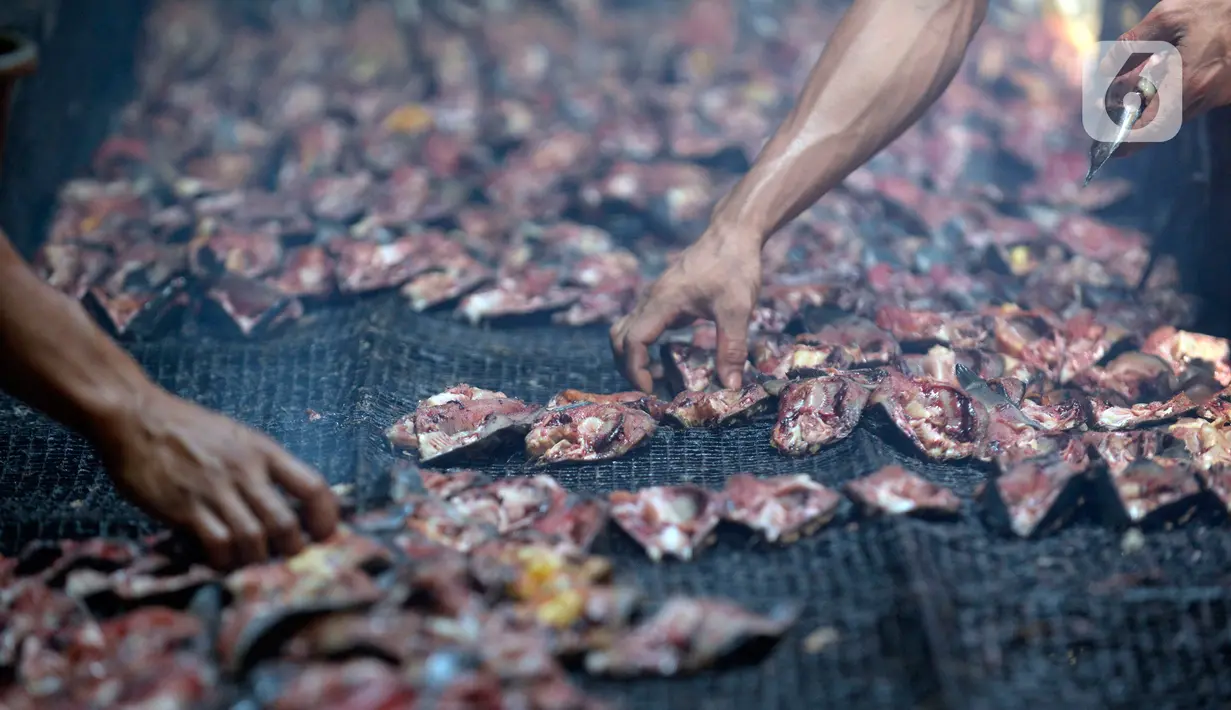 Pekerja menyusun ikan lele yang diasapin (panggang) di Kelurahan Pengasinan, Bogor, Jawa Barat, Jumat (11/09/2020). Permintaan ikan lele asap meningkat dalam satu hari bisa memproduksi 4 sampai 5 kuintal yang akan di kirim ke Jabodetabek hingga di ekspor ke Nigeria. (merdeka.com/Dwi Narwoko)
