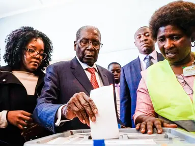 Mantan Presiden Zimbabwe, Robert Mugabe memasukan surat suara dalam pemilihan umum negara itu di TPS distrik Highfield, Harare, Senin (30/7). Mugabe pertama kalinya memberikan suara dalam pemilu, setelah dilengserkan November 2017. (AFP/Zinyange AUNTONY)