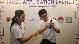 Pendiri Volume Up! dan JakSL Jerick Hartono dan Direktur Sign Language Center Indonesia Laura Lesmana Wijaya berbicara menggunakan bahasa isyarat saat peluncuran  aplikasi JakSL di Jakarta, Kamis (9/8). (Liputan6.com/Fery Pradolo)