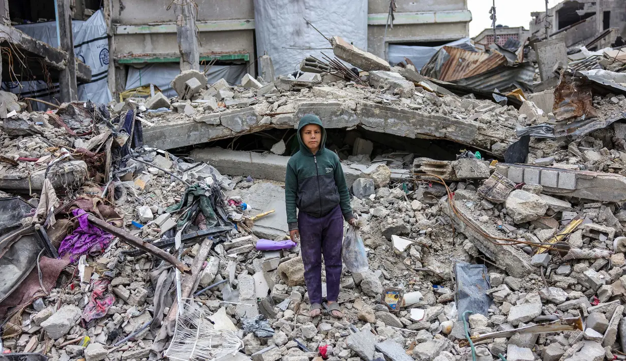 Yazan Kanoua, 10 tahun, berpose di depan rumahnya yang hancur di Jabalia, Jalur Gaza utara, pada 9 Februari 2025. (Bashar TALEB/AFP)
