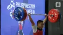 Lifter Eko Yuli melakukan angkatan saat SEA Games 2019 cabang angkat besi nomor 61 kg di Stadion Rizal Memorial, Manila, Filipina, Minggu (1/12/2019). Dirinya meraih emas dengan total angkatan 309 kg. (Bola.com/M Iqbal Ichsan)