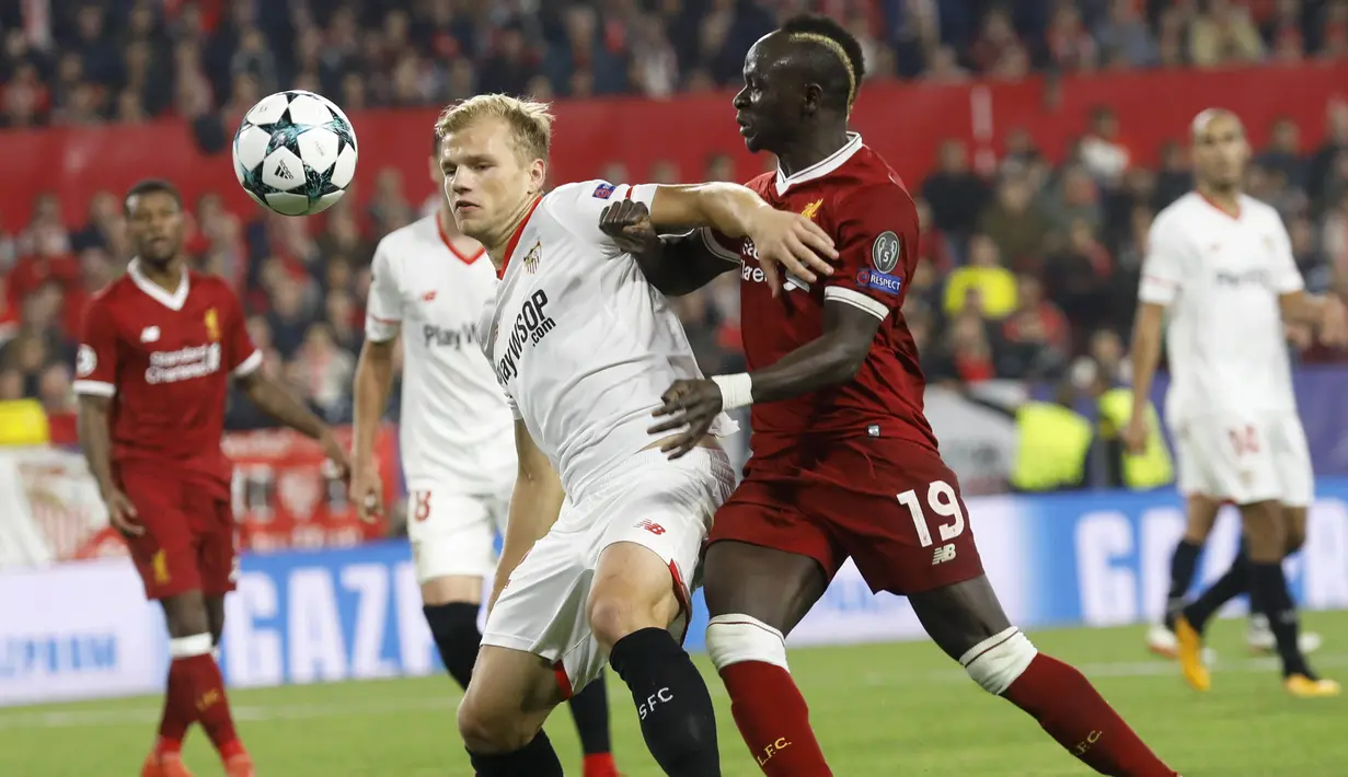 Bek Sevilla, Johannes Geis, mengamankan bola dari kejaran gelandang Liverpool, Sadio Mane, pada laga Liga Champions di Stadion Ramon Sanchez Pizjuan, Sevilla, Selasa (21/11/2017). Kedua klub bermain imbang 3-3. (AP/Miguel Morenatti)