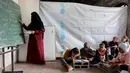 Sekolah Mada merupakan inisiatif untuk memberikan dukungan psikososial dan pendidikan dasar agar anak-anak tidak kehilangan tahun ajaran mereka secara berturut-turut. Tampak dalam foto, anak-anak pengungsi Palestina mengikuti belajar mengajar di dalam tenda di Sekolah Mada, kamp pengungsi Jabalia, Jalur Gaza Utara pada 13 April 2026. (Omar AL-QATTAA/AFP)