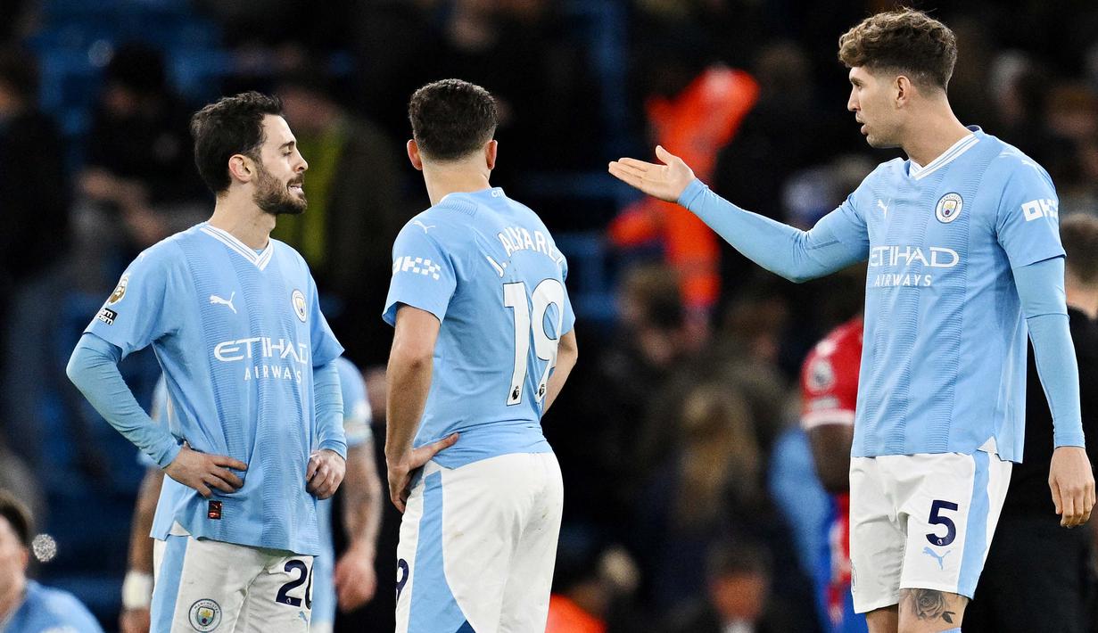 <p>Pemain Manchester City, John Stones, berbincang dengan Bernardo Silva saat melawan Crystal Palace dalam duel pekan ke-17 Liga Inggris 2023/2024 di Stadion Etihad, Sabtu (16/12/2023). Hasil imbang ini menahan posisi Man City di peringkat empat klasemen Liga Inggris dengan 34 poin. (AFP/Paul Ellis)</p>