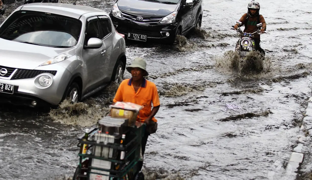 Sejumlah kendaraan melintasi genangan air di kawasan Mangga Dua, Jakarta Utara, Kamis (20/11/2014). (Liputan6.com/Faizal Fanani)