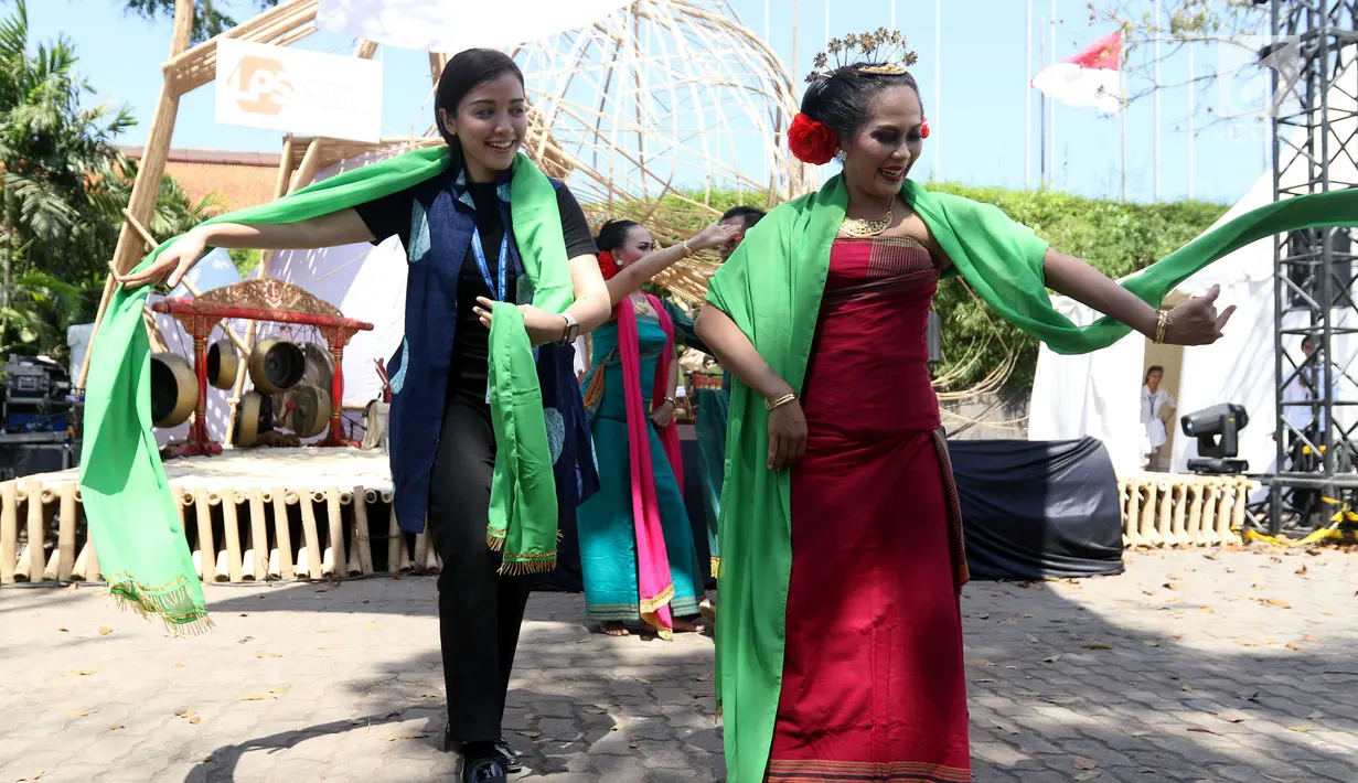 Seorang delegasi ikut menari pada pertunjukkan budaya nusantara di arena Pertemuan Tahunan IMF - World Bank 2018 di Nusa Dua Bali, Jumat (12/10). BeKraf dan LPS menyajikan beragam seni dan budaya Nusantara. (Liputan6.com/Angga Yuniar)