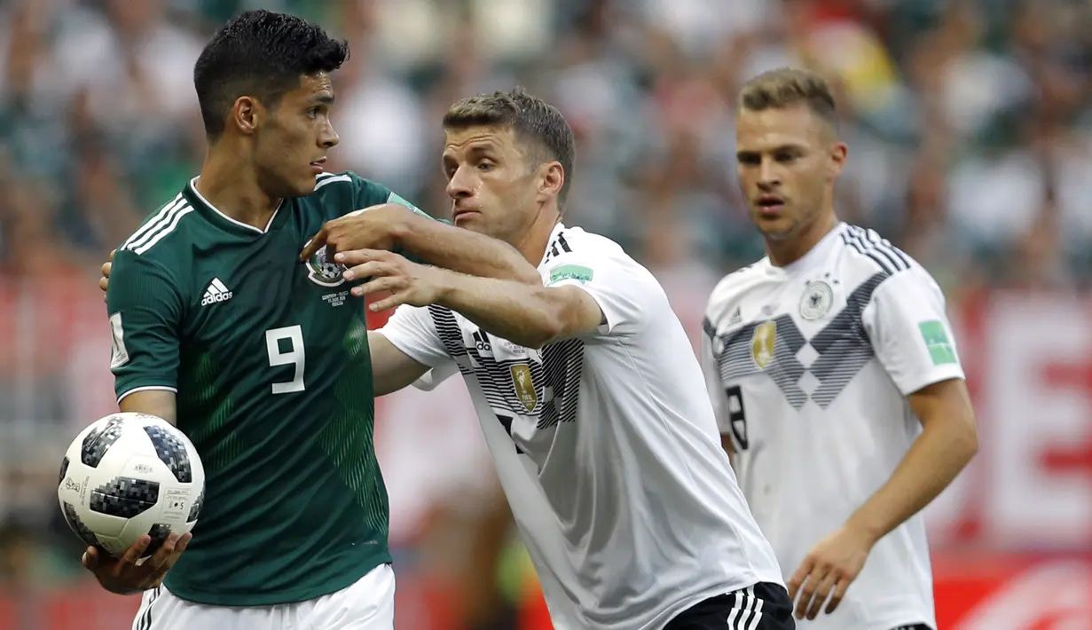 Gelandang Jerman, Thomas Mueller, berusaha merebut bola dari striker Meksiko, Raul Jimenez, pada laga Grup F Piala Dunia di Stadion Luzhniki, Moskow, Minggu (17/6/2018). Meksiko menang 1-0 atas Jerman. (AP/Victor Caivano)