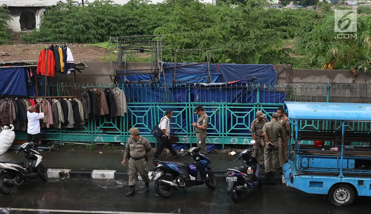 Personel Satpol PP berjaga di sekitar trotoar kawasan Senen, Jakarta, Kamis (22/11). Penjagaan itu menyebabkan trotoar di kawasan Senen bebas dari PKL yang biasa berjualan pakaian bekas. (Liputan6.com/Immanuel Antonius)