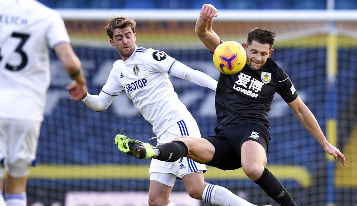 Striker Leeds United, Patrick Bamford, berebut bola dengan pemain Burnley, James Tarkowski, pada laga Liga Inggris di Stadion Elland Road, Minggu (27/12/2020). Leeds United menang dengan skor 1-0. (Oli Scarff/Pool via AP)