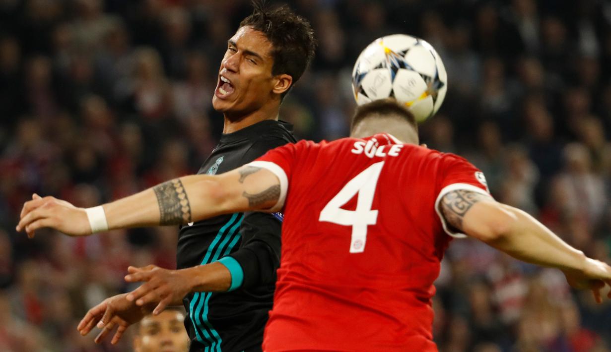 Bek Bayern Munchen, Niklas Suele berebut bola dengan pemain Real Madrid, Raphael Varane pada leg pertama semifinal Liga Champions di Allianz Arena, Rabu (25/4). Real Madrid meraih kemenangan 2-1 saat bertandang ke markas Bayern Munchen. (Odd ANDERSEN/AFP)