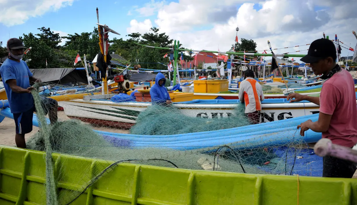 Nelayan menyiapkan jaring mereka sebelum berangkat ke laut setelah matahari terbenam saat Pemberlakuan Pembatasan Kegiatan Masyarakat (PPKM) Level 3 di Kedonganan, Kuta, Badung, Bali, Jumat (23/7/2021). Selama PPKM Level 3 di Bali, sektor esensial diizinkan buka namun dibatasi. (SONY TUMBELAKA/AFP)