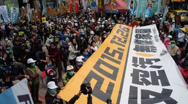 Demonstran mengunakan masker membawa spanduk raksasa saat unjuk rasa menuntut pemerintah Taiwan dalam pengurangan polusi udara di Taipei (26/12). Ratusan warga berbaris di jalan-jalan memprotes kebijakan energi pemerintah. (AFP PHOTO/Sam Yeh)