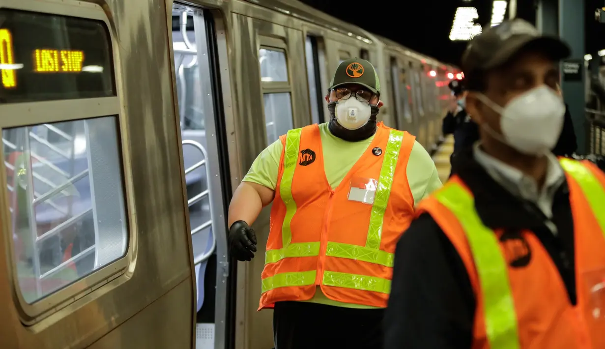 Pekerja otoritas transportasi kota New York bersiap membersihkan gerbong kereta bawah tanah dengan disinfektan di stasiun Coney Island di Brooklyn, Rabu (6/5/2020). Sistem kereta bawah tanah New York dimatikan sementara untuk dibersihkan guna menghentikan penyebaran Covid-19. (AP/Frank Franklin II)