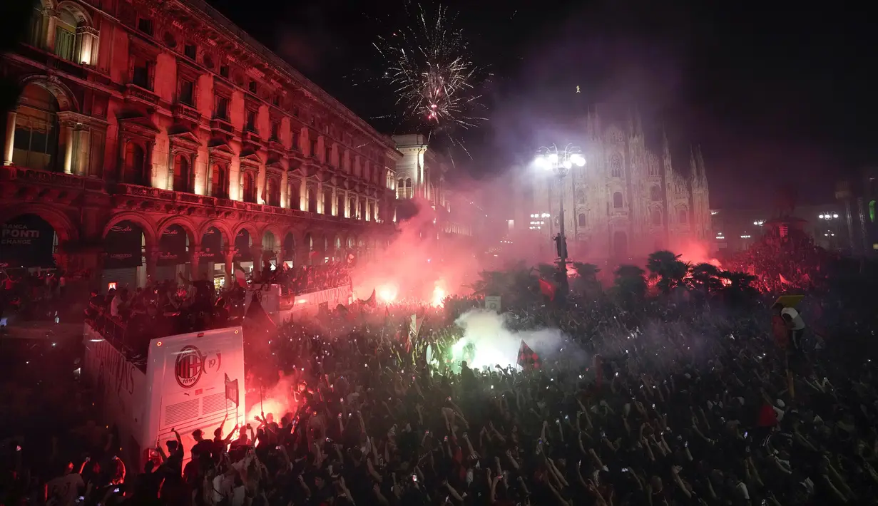 Ribuan penggemar bersorak saat bus yang membawa para pemain tim sepak bola AC Milan melakukan parade kemenangan Liga Italia di depan Katedral Gotik Milan, Milan, Italia, 23 Mei 2022. (AP Photo/Luca Bruno)