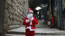 Seorang anak laki-laki yang mengenakan kostum Sinterklas terlihat di Kota Tua Yerusalem (7/12/2020). (Xinhua/Muammar Awad)