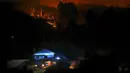 Mobil pemadam kebakaran diparkir dekat rumah-rumah untuk melindungi mereka dari kebakaran hutan yang mengamuk di Desa Serra do Branco, dekat Leiria, Portugal, 12 Juli 2022. Ratusan petugas pemadam kebakaran di Portugal terus memadamkan api di pusat negara yang memaksa evakuasi puluhan orang dari rumah mereka sebagian besar di desa-desa sekitar Santarem, Leiria, dan Pombal. (AP Photo/Joao Henriques)