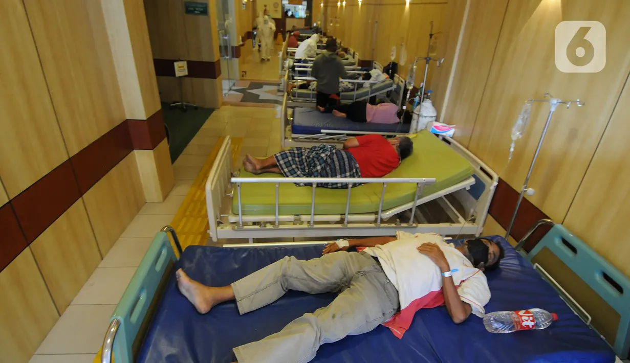 Pasien covid-19 saat perawatan pasien khusus virus corona pada lorong UGD di RSUD Kota Bekasi, Jumat (25/06/2021). Puluhan pasien covid-19 saat ini dirawat dalam tenda darurat karena keterisian tempat tidur yang penuh akibat lonjakan kasus. (merdeka.com/Arie Basuki)