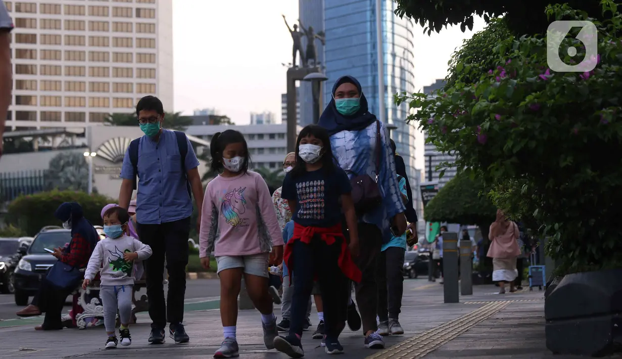 Warga berjalan saat berada di kawasan Bundaran HI, Jakarta, Jumat (31/12/2021). Polda Metro Jaya melarang perayaan malam tahun baru 2022 di seluruh wilayah DKI Jakarta. Kebijakan itu berlaku mulai 31 Desember 2021 hingga 2 Januari 2022. (Liputan6.com/Angga Yuniar)