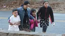 Seorang wanita membawa tiga orang anak menjauh dari lokasi kecelakaan bus sekolah di Chattanooga, Tennessee, Senin (21/11). Belum ada kejelasan penyebab kecelakaan bus yang ditemukan terbaring di antara pepohonan itu (Courtesy of Angela Lewis/Chattanooga)