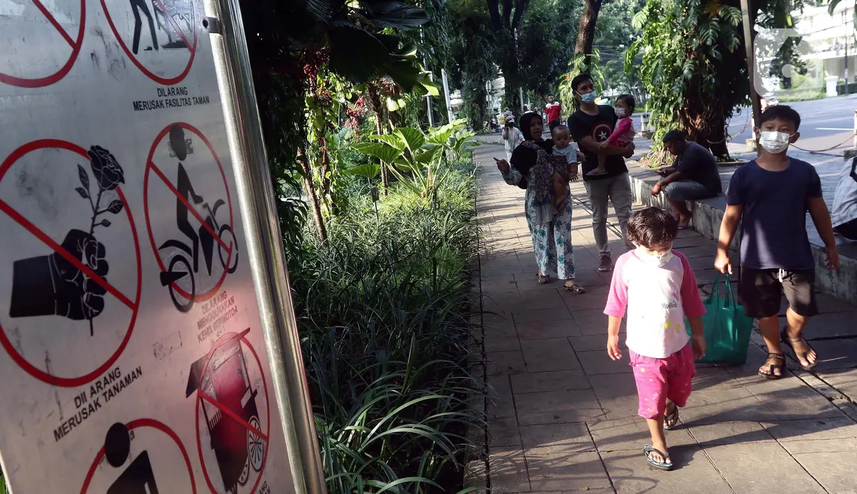Anak-anak bersiap masuk ke ruang terbuka hijau Taman Suropati, Jakarta, Sabtu (23/10/2021). Selama berada di ruang terbuka hijau, pengunjung diwajibkan mematuhi protokol kesehatan, seperti mencuci tangan, mengenakan masker dan menghindari kerumunan. (Liputan6.com/Helmi Fithriansyah)