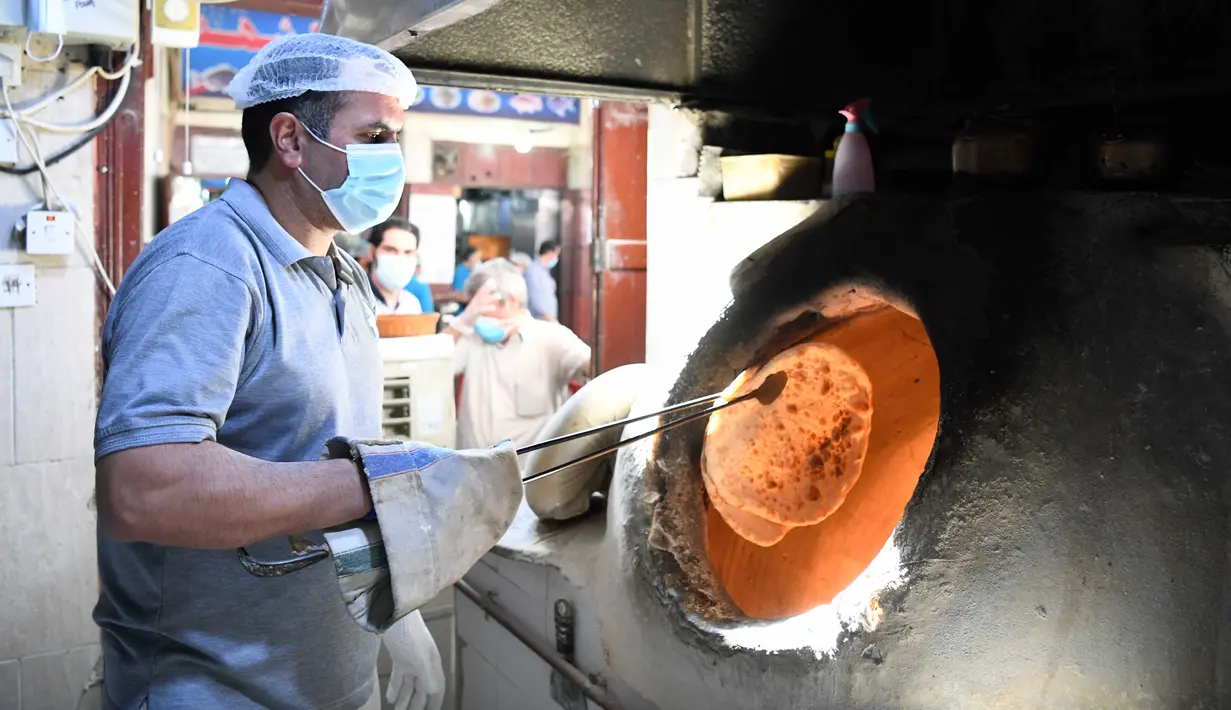 Seorang pria memanggang roti di sebuah restoran di pasar Al-Mubarakiya, Kuwait (18/8/2020). Pemerintah negara itu mengizinkan salon, pusat kebugaran, tempat pangkas rambut, penjahit, dan spa untuk kembali beroperasi, sementara restoran dapat menawarkan lebih banyak layanan. (Xinhua/Ghazy Qaffaf)