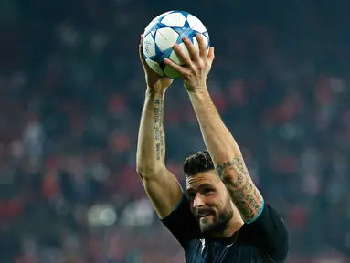 Penyerang Arsenal, Olivier Giroud melakukan selebrasi dengan mengangkat bola usai mencetak hattrick melawan Olympiakos di Stadion Georgios Karaiskakis, Piraeus, Yunani  (9/12). Arsenal menang atas Olympiakos dengan skor 3-0. (Reuters/Andrew Couldridge)