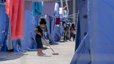 Seorang anak Afghanistan menyapu di kamp pengungsian Palang Merah Italia, Avezzano, Italia, Selasa (31/8/2021). Kamp karantina ini menampung 1.250 imigran. (AP Photo/Andrew Medichini)