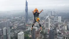 Seorang pelompat BASE terjun dari Menara Kuala Lumpur selama KL Tower International Jump Malaysia di Kuala Lumpur, Jumat (3/2/2023). Event wisata olahraga ini mengajak traveler penantang adrenalin untuk base jump, semacam terjun bebas, dari sisi atas menara di ketinggian sekitar 300 meter. (AP Photo/Vincent Thian)
