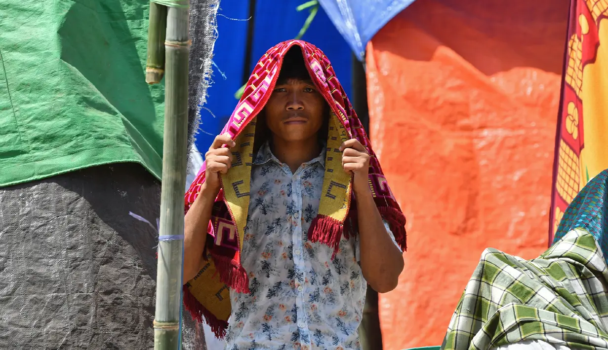 Korban gempa Lombok bersiap melakukan salat di sebuah ladang dekat tempat penampungan sementara di Pemenang, Lombok Utara, Jumat (10/8). (ADEK BERRY/AFP)